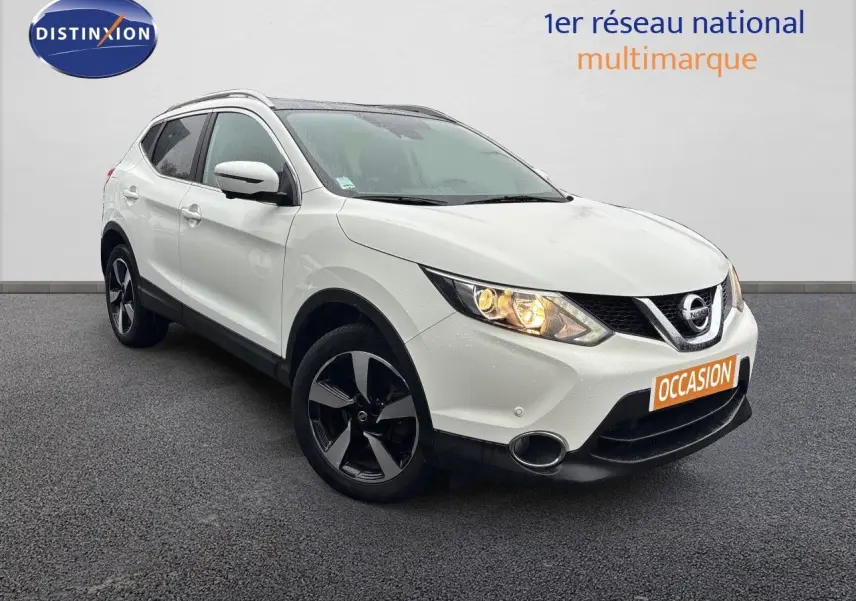 Nissan Qashqai blanc glacier en 3/4 avant droit avec jantes noires et phares allumés sur fond neutre.
