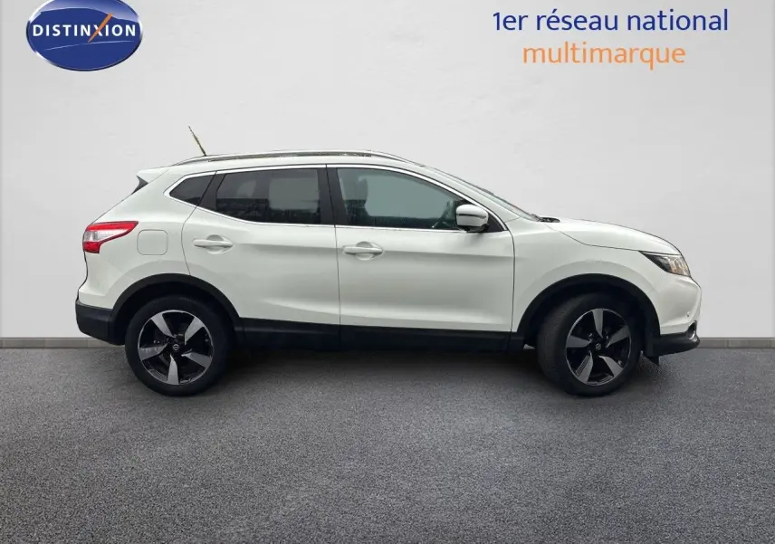 Nissan Qashqai blanc glacier vu de profil côté gauche sur fond neutre, avec jantes bi-ton et toit ouvrant.