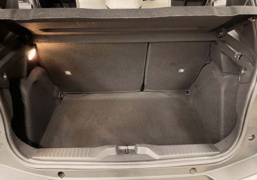 Vue intérieure du coffre spacieux et propre d'une Citroën C3 électrique gris 2025, éclairage latéral allumé.