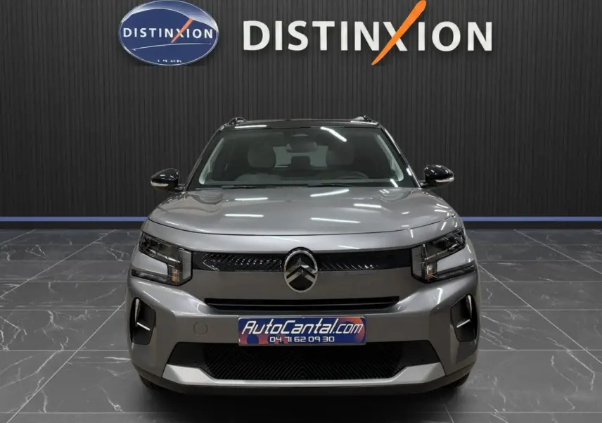 Vue frontale d'une Citroën C3 électrique gris métallisé, avec calandre noire et éclairage LED moderne.