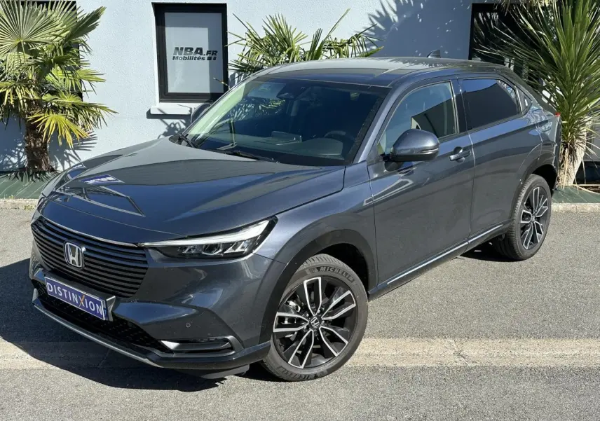 Honda HR-V gris métallisé vu en 3/4 avant droit avec jantes alliage 18 pouces et calandre noire lisse