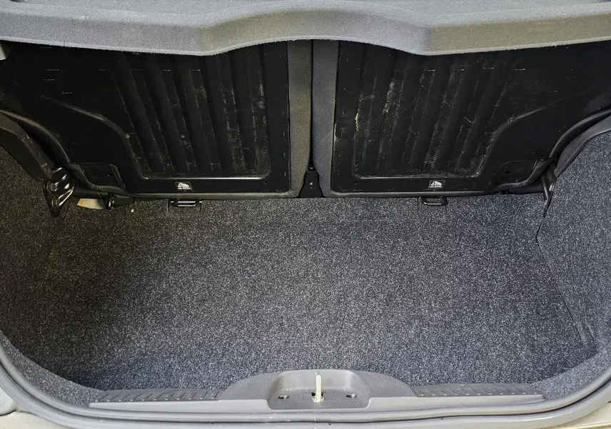 Coffre ouvert d'une FIAT 500 gris 2023, vue arrière montrant l'espace de chargement vide et la moquette intérieure.