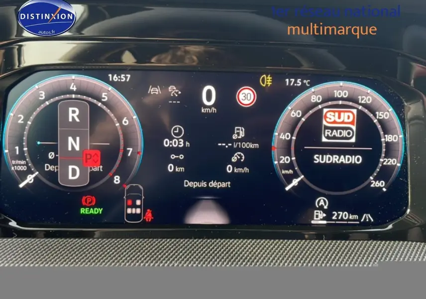 Vue rapprochée du tableau de bord numérique de la Volkswagen Golf gris, affichant la vitesse, régime et radio Sud Radio.