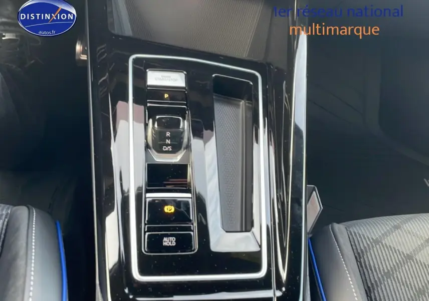 Vue rapprochée de la console centrale noire brillante avec levier de vitesses automatique sur Volkswagen Golf gris 2026.