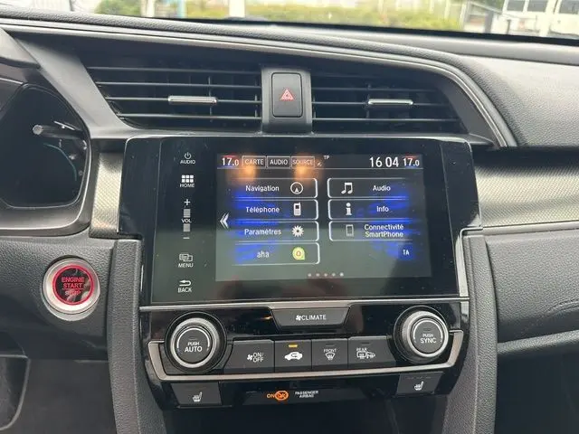 Vue rapprochée du tableau de bord de la Honda Civic grise, avec écran tactile central et commandes climatisation visibles.
