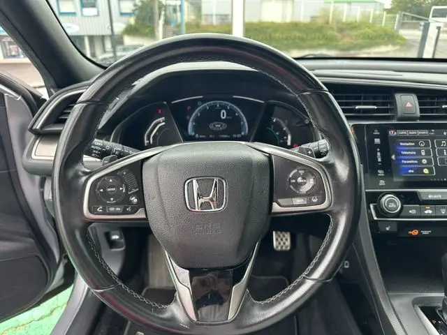 Vue centrée sur le volant en cuir noir de la Honda Civic 2019, avec tableau de bord et écran tactile visibles.