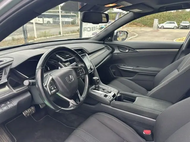 Vue intérieure côté conducteur de la Honda Accord grise 2019, montrant le volant cuir et la console centrale avec boîte auto.