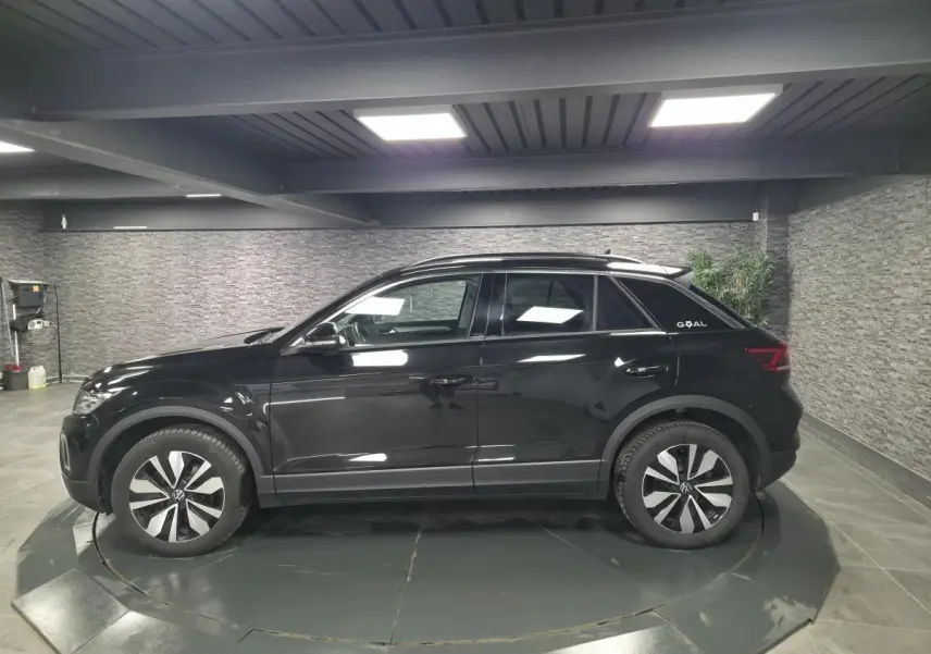 Volkswagen T-Roc noir en vue de profil côté gauche, avec jantes spécifiques et badge Goal à l'arrière.