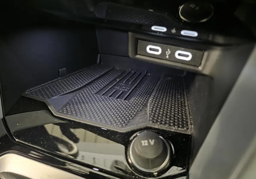 Gros plan sur la console centrale noire du Volkswagen T-Roc 2025 avec ports USB-C et prise 12V visible.