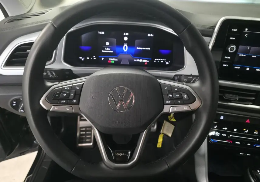 Volant noir multifonction Volkswagen T-Roc 2025 avec tableau de bord digital et écran tactile central visible de face.
