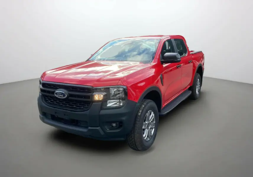 Ford Ranger 2025 rouge racing en vue 3/4 avant droit avec calandre noire et phares allumés.