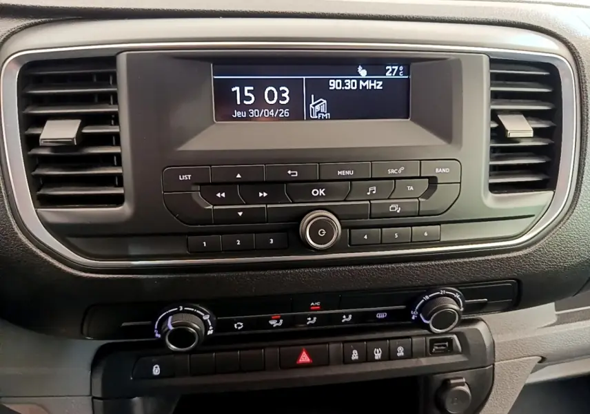 Vue rapprochée du tableau de bord noir du Peugeot Traveller 2018 avec écran central et commandes de climatisation.