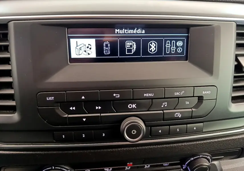 Vue rapprochée du tableau de bord du Peugeot Traveller 2018 blanc, mettant en valeur l’écran multimédia et les commandes audio.
