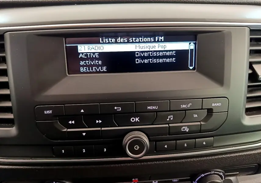 Tableau de bord du Peugeot Traveller 2018 avec écran radio FM et commandes noires en vue frontale rapprochée.