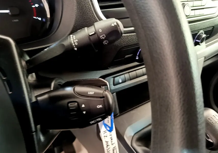 Gros plan sur la colonne de direction et le levier de vitesses manuel d’un Peugeot Traveller blanc de 2018.