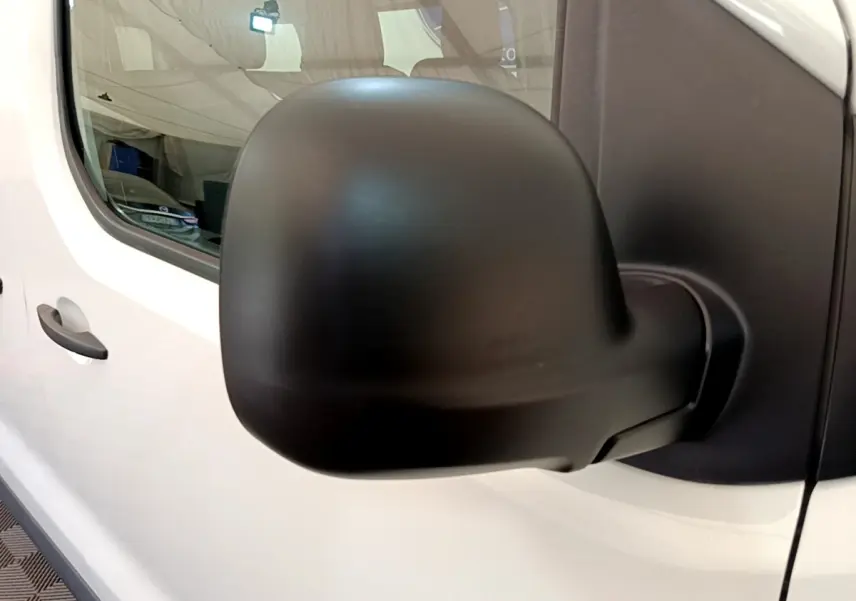 Rétroviseur noir en gros plan côté gauche du Peugeot Traveller blanc diesel de 2018, vue sur la porte avant.