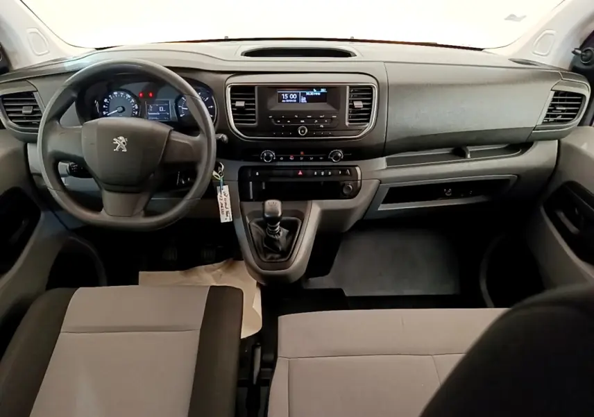 Vue intérieure avant du Peugeot Traveller 2018 avec tableau de bord noir et leviers de vitesses manuelle visibles.