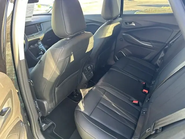 Vue intérieure côté arrière droit de l’Opel Grandland 2020 noire, montrant les sièges arrière en cuir noir et la console centrale.