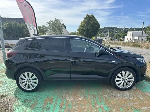 Vue latérale droite d'un Opel Grandland noir de 2020, avec jantes alliage et vitres teintées, stationné en extérieur.