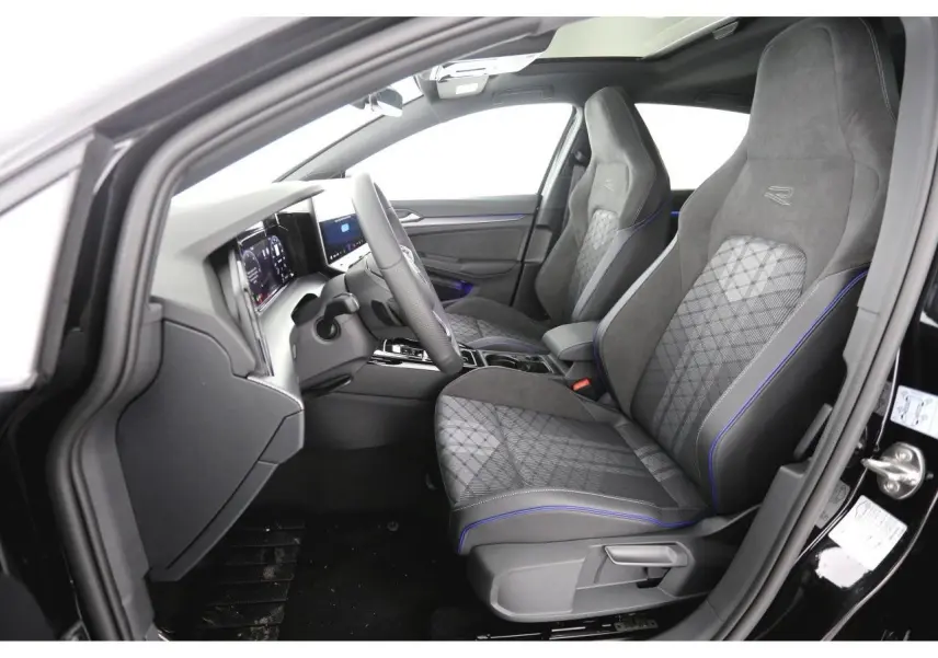 Vue intérieure côté conducteur de la Volkswagen Golf VIII R-Line avec sièges sport gris à surpiqûres bleues et tableau de bord digital.