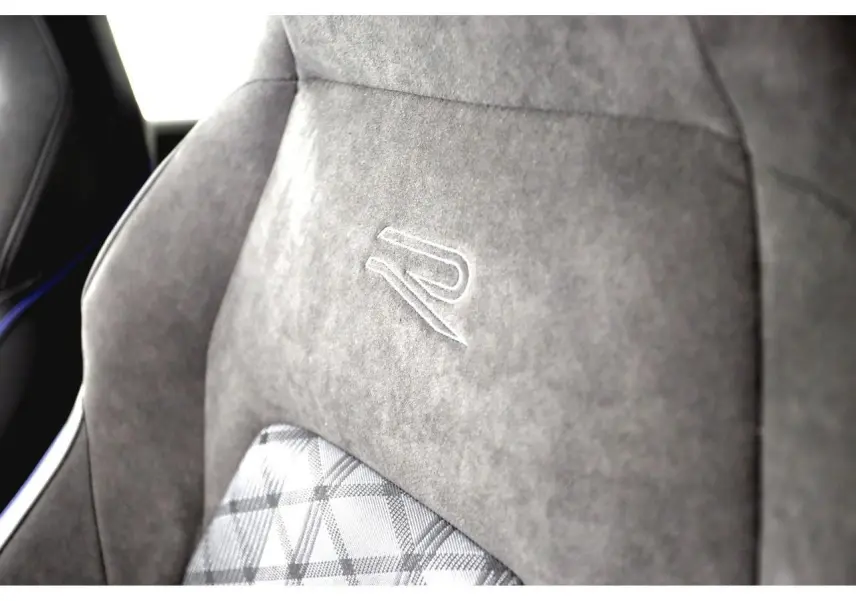Gros plan sur le siège avant en alcantara gris avec logo R brodé, intérieur sportif de la Volkswagen Golf VIII R-Line.