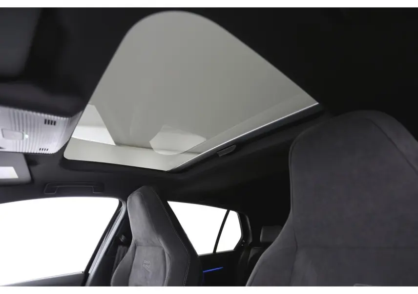 Vue intérieure montrant le toit ouvrant panoramique et les sièges sport R-Line en tissu gris foncé de la Volkswagen Golf VIII.