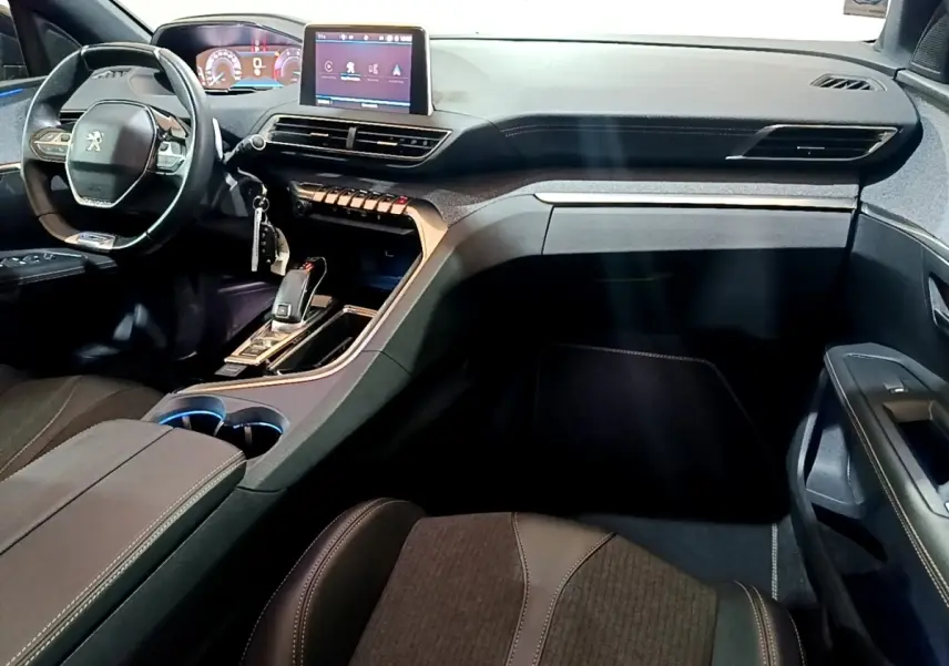 Vue intérieure côté passager du tableau de bord et volant cuir du Peugeot 3008 GT Line gris foncé, avec écran tactile central.