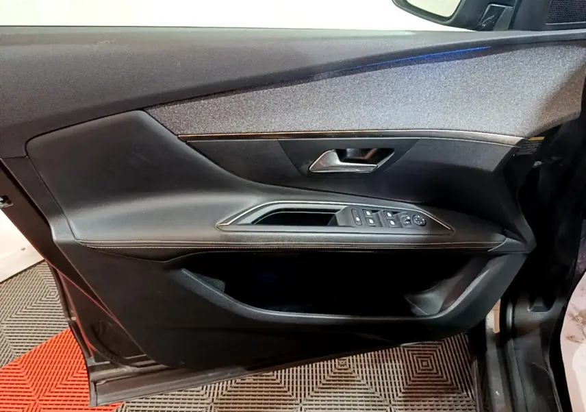 Porte avant gauche de Peugeot 3008 gris foncé, avec commandes électriques et poignée intérieure chromée.