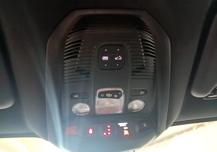 Vue intérieure en gros plan du plafonnier avec commandes d’éclairage et alertes du Peugeot 3008 gris foncé.