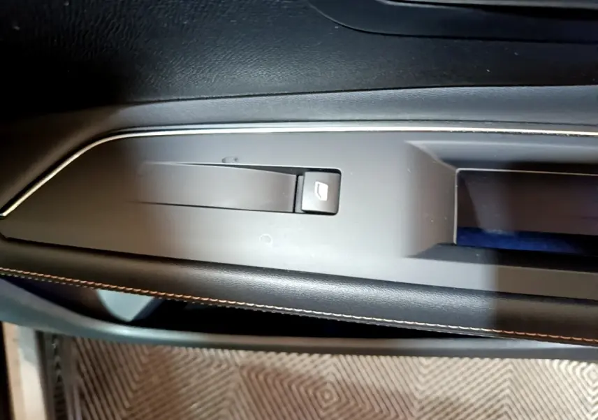 Détail de la commande électrique de frein à main sur la console centrale noire du Peugeot 3008 GT Line gris foncé.