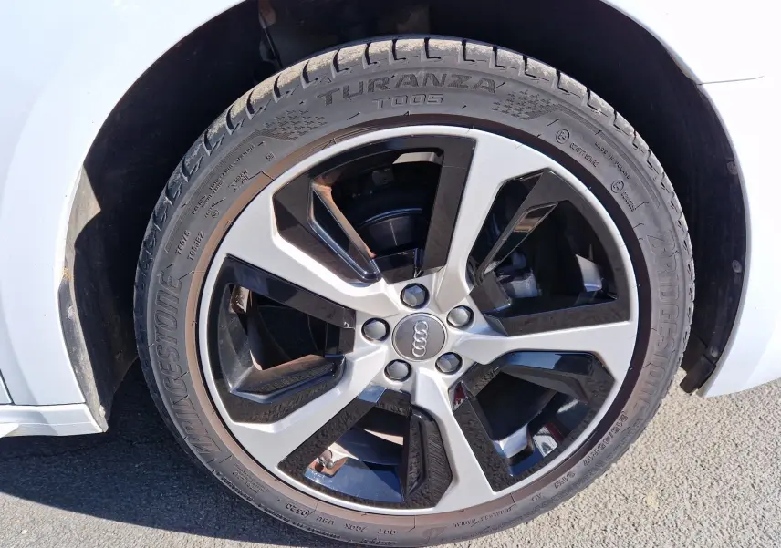 Gros plan sur la jante alliage noire et argentée de l'Audi A1 Sportback blanc glacier, avec pneu Bridgestone Turanza.