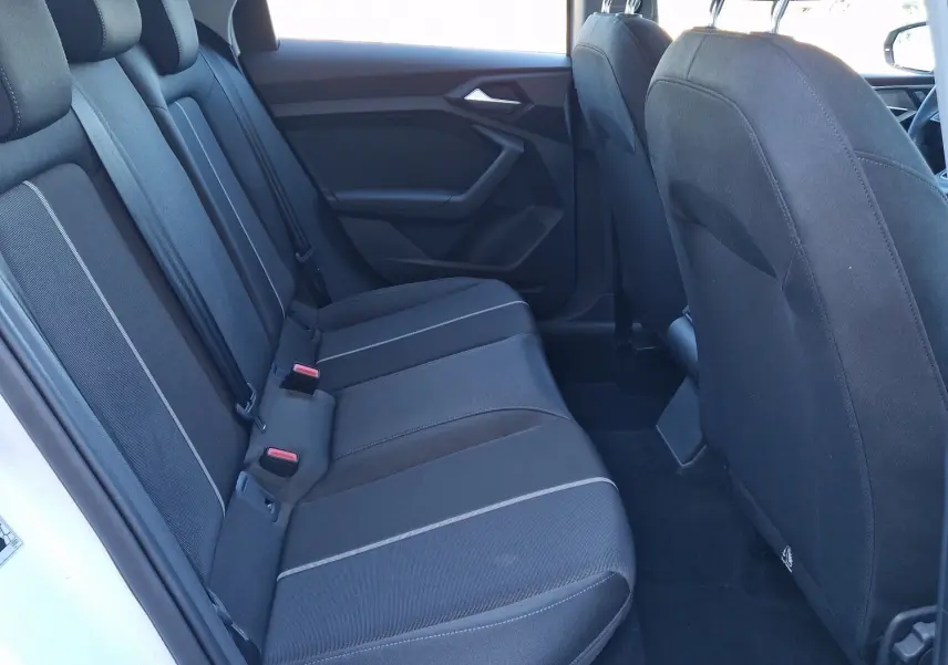 Vue intérieure côté gauche montrant les sièges arrière noirs d'une Audi A1 Sportback blanc glacier 2020.