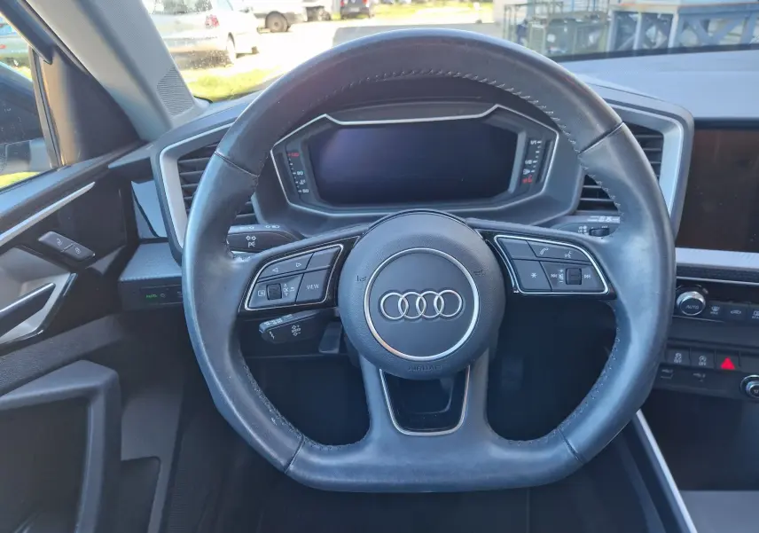Vue intérieure centrée sur le volant cuir de l'Audi A1 Sportback 2020 avec tableau de bord numérique éteint.