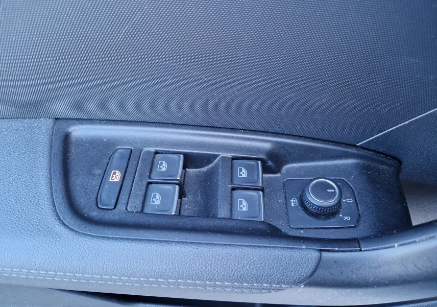 Gros plan sur les commandes des vitres et rétroviseurs côté gauche d’une Audi A1 Sportback blanc glacier.