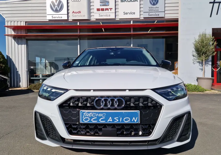 Vue frontale d'une Audi A1 Sportback blanc glacier 2020 avec calandre noire hexagonale et phares LED.