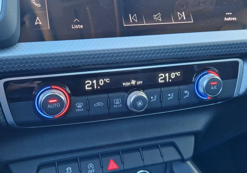 Gros plan sur la commande de la climatisation automatique de l'Audi A1 Sportback blanc glacier, affichant 21°C des deux côtés.