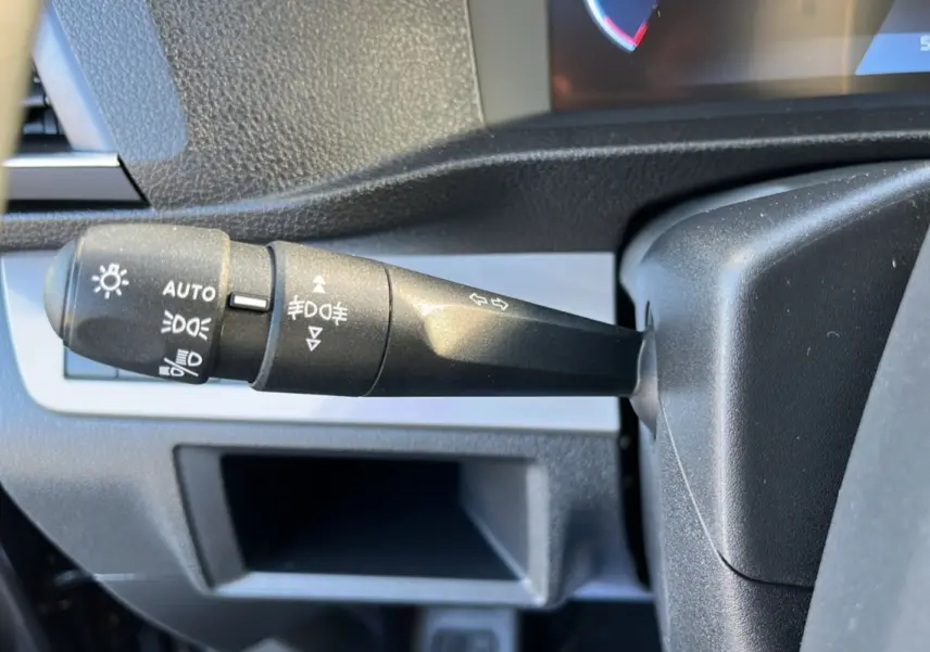 Gros plan sur la manette de commande des feux et clignotants dans l'habitacle du Peugeot Traveller gris titane.