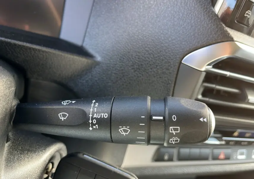 Gros plan sur la commande des essuie-glaces du Peugeot Traveller 2025, intérieur noir avec détails argentés.