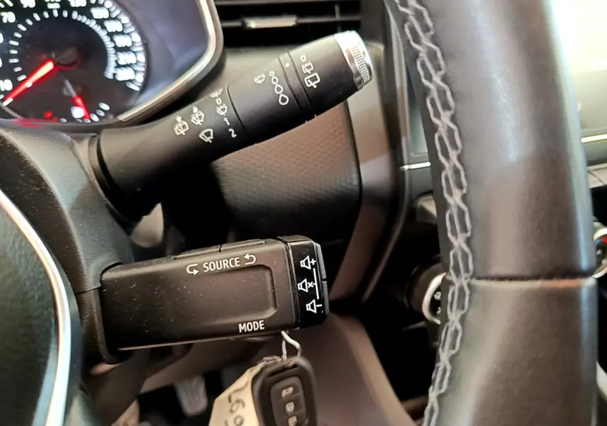 Gros plan sur la commande multimédia au volant d’une Renault Clio Business Blue dCi 85, intérieur noir.