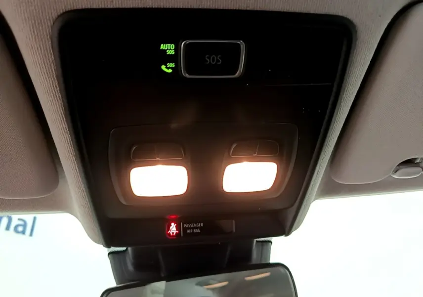 Vue intérieure du plafonnier avec éclairage allumé et témoin d'airbag passager dans une Renault Clio blanche de 2020.