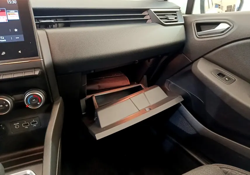 Vue intérieure côté passager de la Renault Clio Business Blue dCi 85 2020, boîte à gants ouverte et tableau de bord noir.