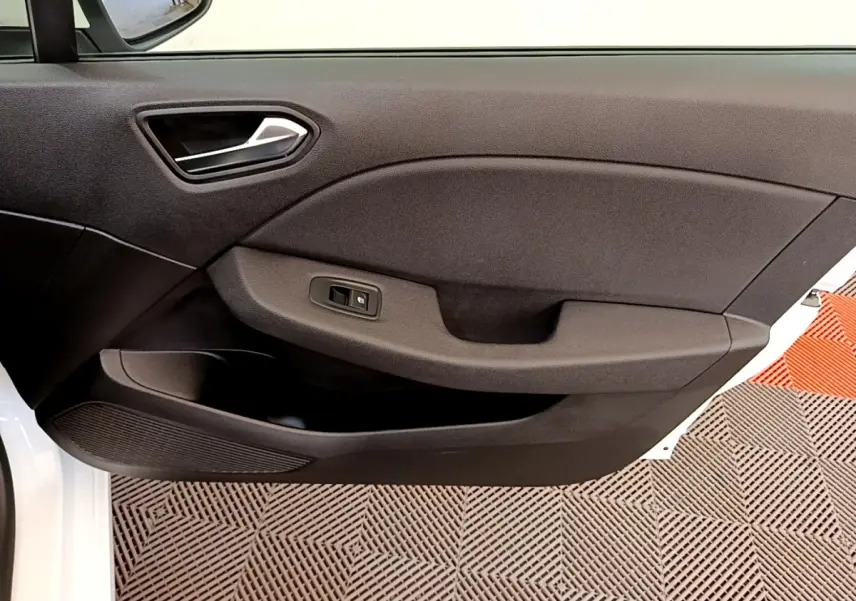 Vue rapprochée de la porte avant gauche noire de la Renault Clio Business Blue dCi 85 blanche, avec commande de fenêtre.