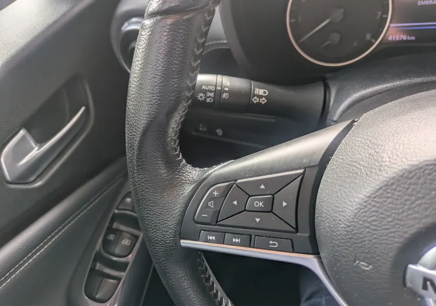 Gros plan sur le volant noir du Nissan Juke 2020, avec commandes multifonctions et partie du tableau de bord visible.