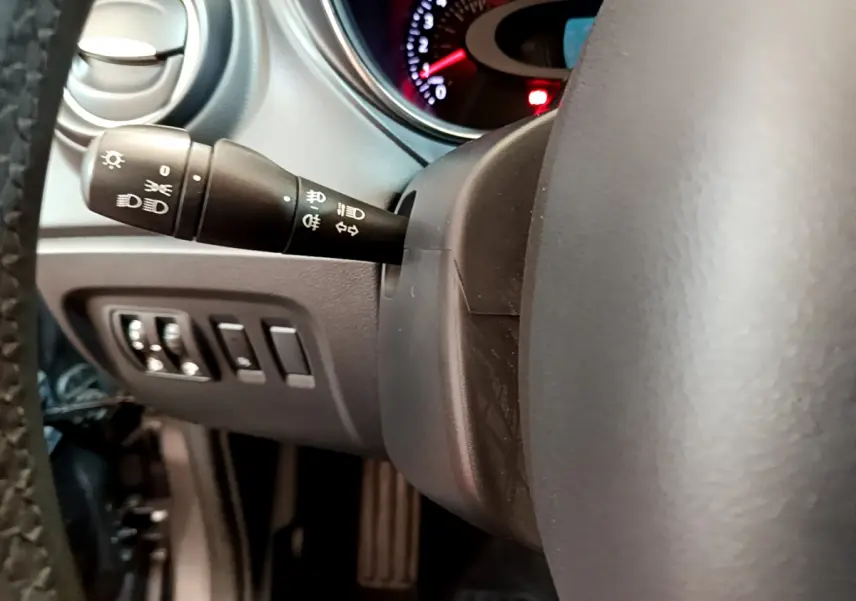 Gros plan sur la manette des phares et clignotants à gauche du volant cuir dans le Renault Captur gris foncé 2018.