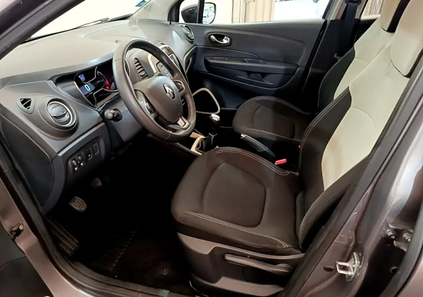 Intérieur côté conducteur du Renault Captur gris foncé 2018, avec volant cuir multifonctions et sièges bicolores noirs et beiges.