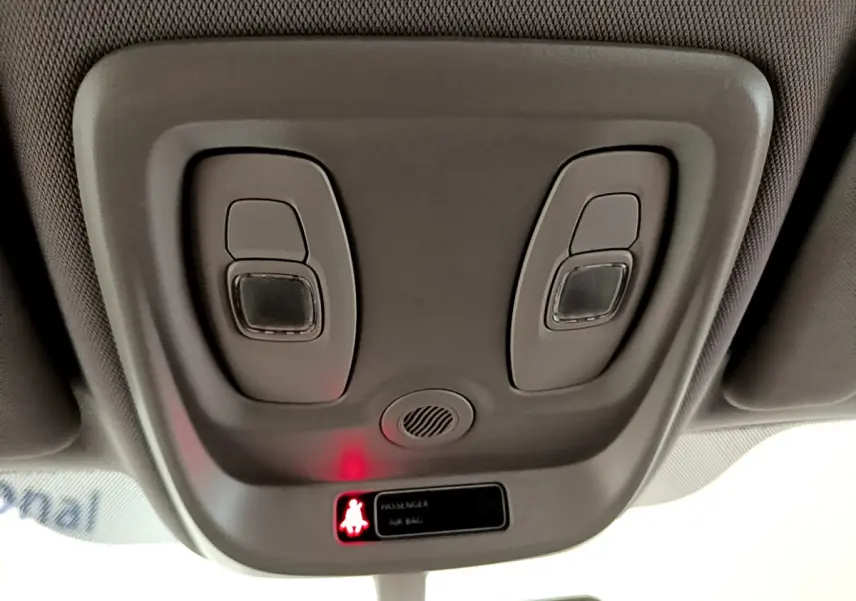 Vue rapprochée du plafonnier gris clair du Renault Captur Business avec éclairage et témoin airbag passager allumé.