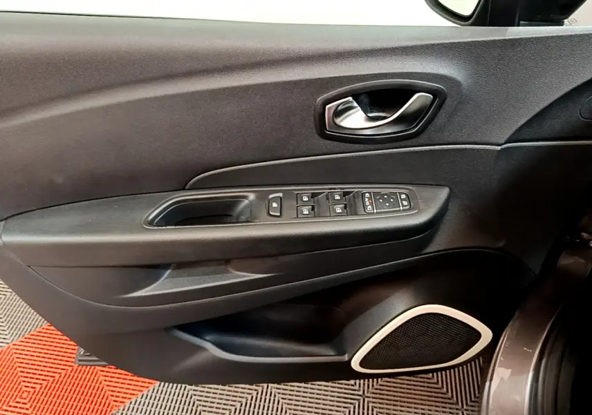 Gros plan sur la porte côté conducteur du Renault Captur gris foncé, avec commandes électriques et haut-parleur intégré.