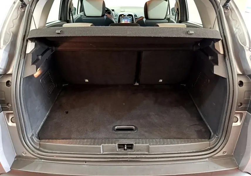 Coffre ouvert d'un Renault Captur gris foncé vu de l'arrière, montrant la banquette arrière et la tablette cache-bagages.