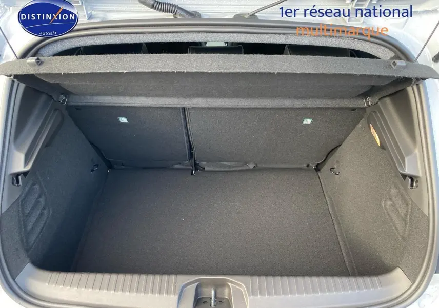 Coffre ouvert vu de dessus d'une Renault Clio V gris rafale, montrant l'espace de rangement intérieur.