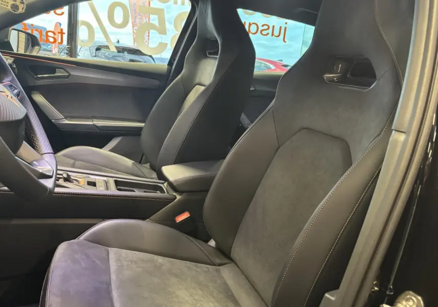 Vue intérieure côté droit montrant les sièges baquets suédine noir Asphalte avec surpiqûres cuivrées du CUPRA Leon 2026.